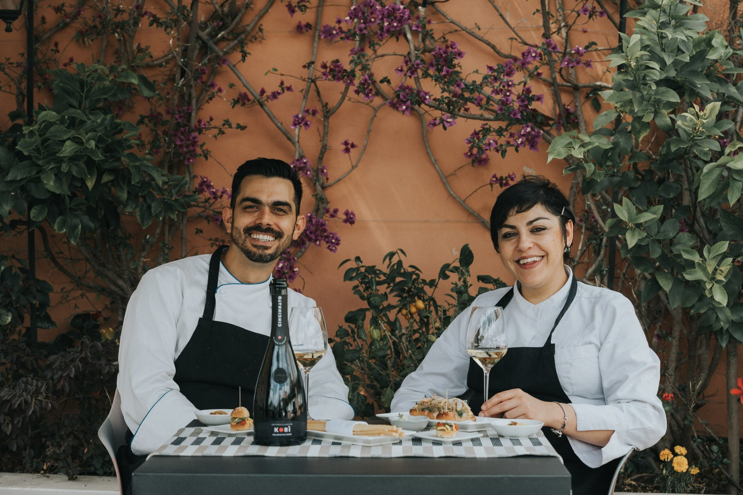 Nella foto a destra lo chef Adriano Magnoli e la Pastry Chef Antonella Mascolo con due calici di Korì Pas Dosé di Cincinnato